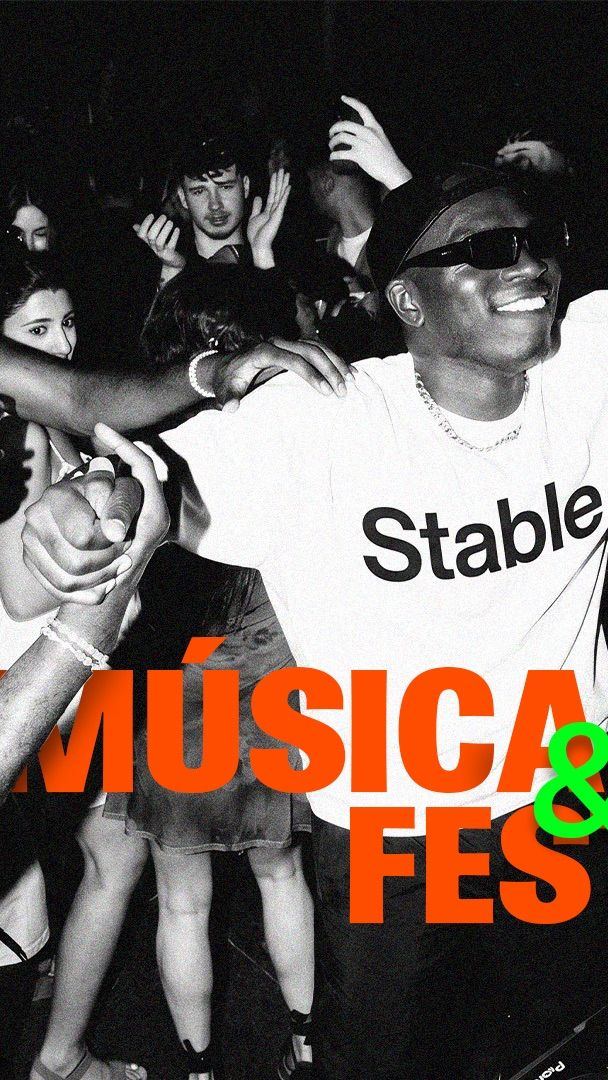 Multitud bailando frente a la cabina del DJ en una fiesta nocturna, con una camiseta Stable al centro